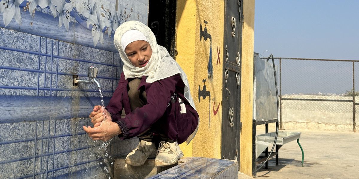 Syrská dívka si umývá ruce v centru neformální vzdělávání uprostřed tábora pro vnitřně vysídlené.